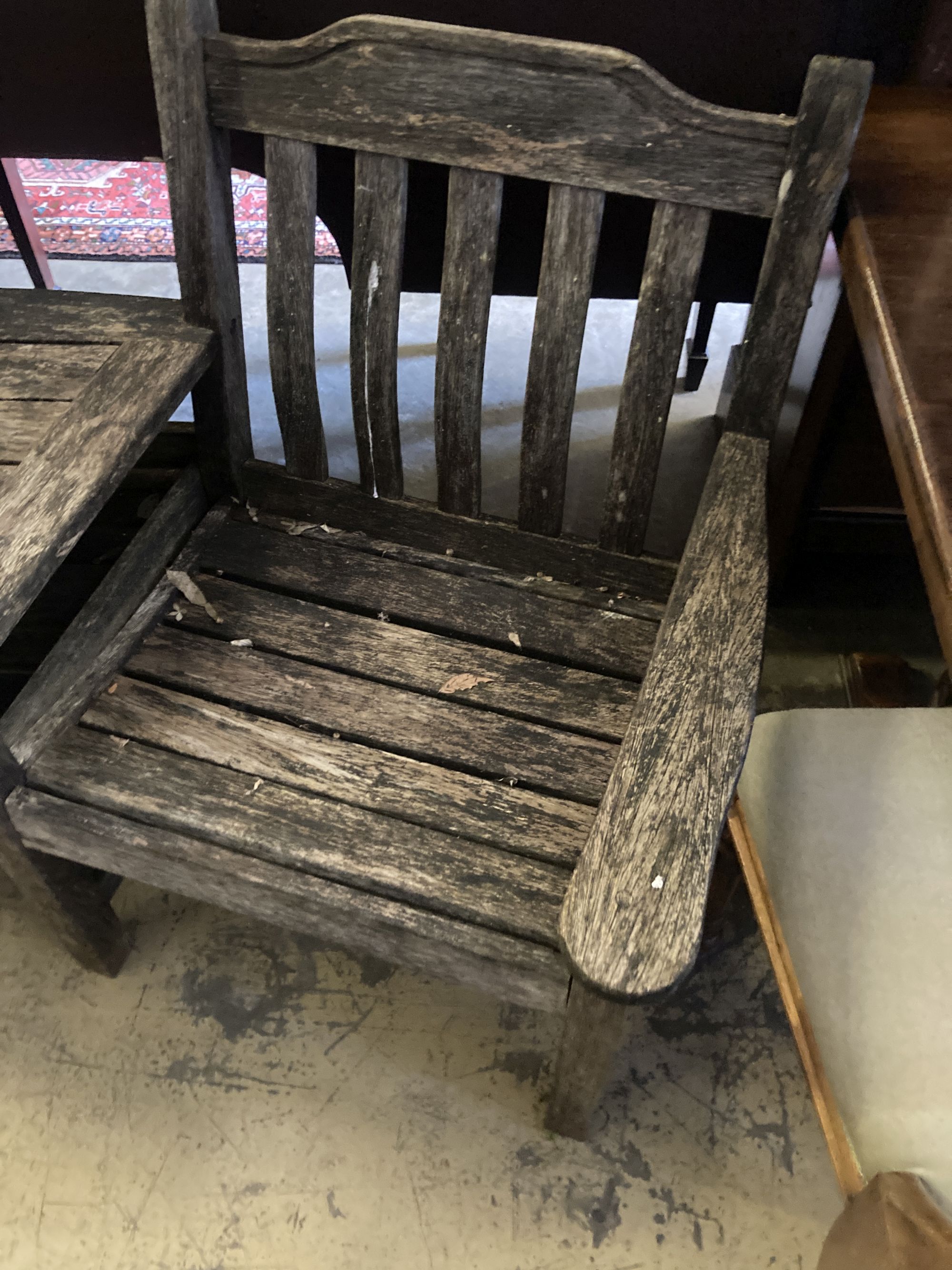 A weathered teak garden conversation seat, length 163cm, depth 80cm, height 86cm, together with a Gloster rectangular teak low garden t